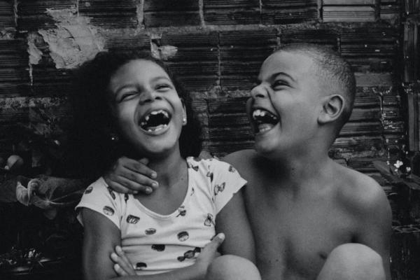 a black and white photograph of two children laughing together
