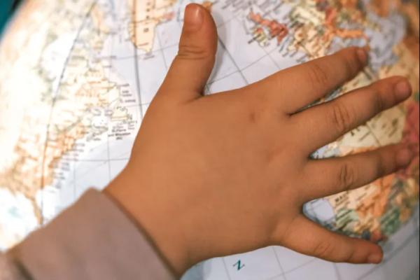 a photograph of a child's hand on a globe