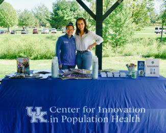 a photograph of Doris Castellanos and Olivia L Silva Padilla behind their booth at the event