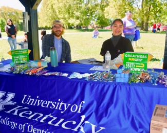 a photograph of Zack Dickinson and Kiara M Perdomo Perez behind a booth at the event