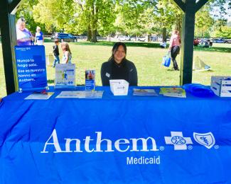 a photograph of Jackeline Almaraz behind an Anthem Medicaid booth at the event