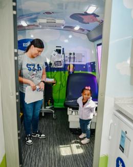 a photograph of a child visiting a medical bus at the event