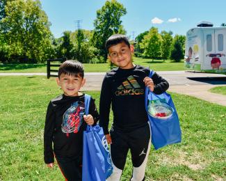 a photograph of two children with goodie bags at the event